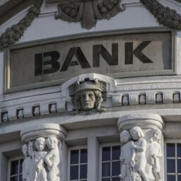 a picture of a bank. Bank is a financial institution. Like a house with a truckload of money in it.
