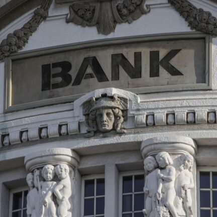 a picture of a bank. Bank is a financial institution. Like a house with a truckload of money in it.