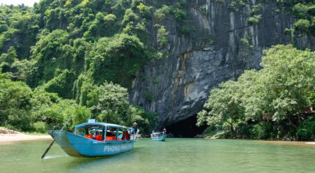 a river boat on a river, surrounded by river banks
