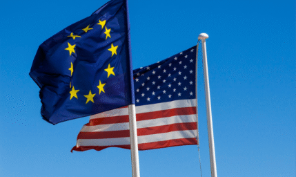 European Union and United States flags against blue sky backdrop