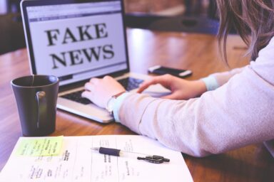 laptop with a Fake News sign