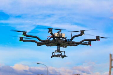 A military drone flying against a blue sky