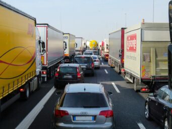 Heavy-duty trucks and cars stuck in motorway traffic