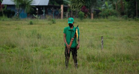 Amazon indigenous person in a green cap