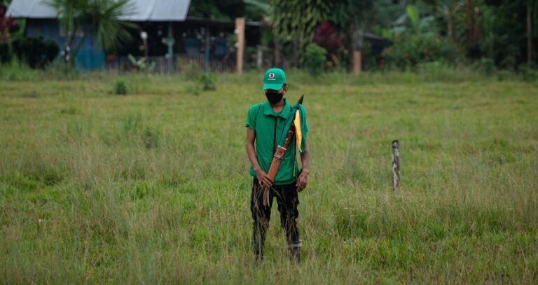 Amazon indigenous person in a green cap