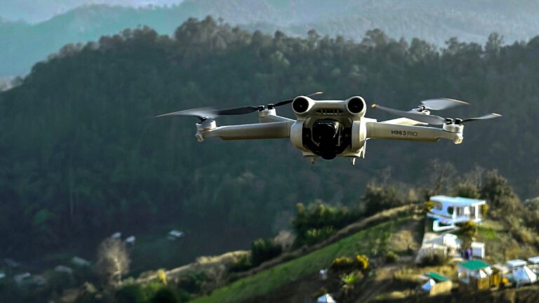 A drone flying over a hilly, forested landscape