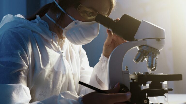 A young scientist examining samples under a microscope in a laboratory
