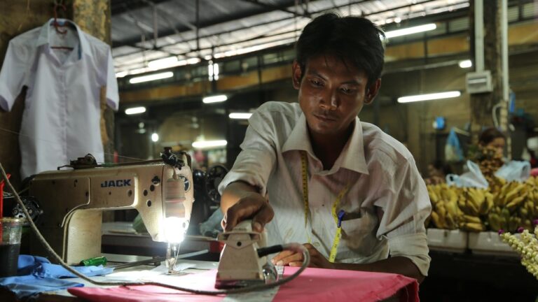 Man working at a sewing machine in a Cambodian factory