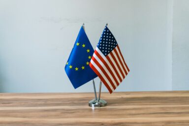 EU and US flags on stands on a table