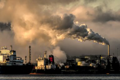 Industrial port with smoke emissions from factory chimneys