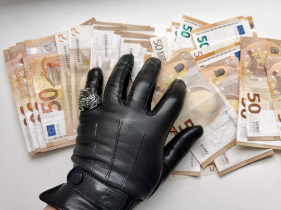gloved hand on euro banknotes