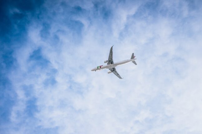 Passenger aircraft flying against a blue sky