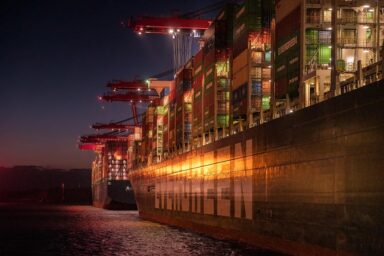 Container ship loaded with cargo docked at port at night