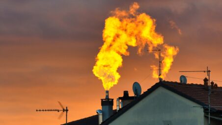 Rooftop with a smoking chimney at sunset