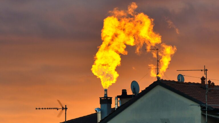 Rooftop with a smoking chimney at sunset