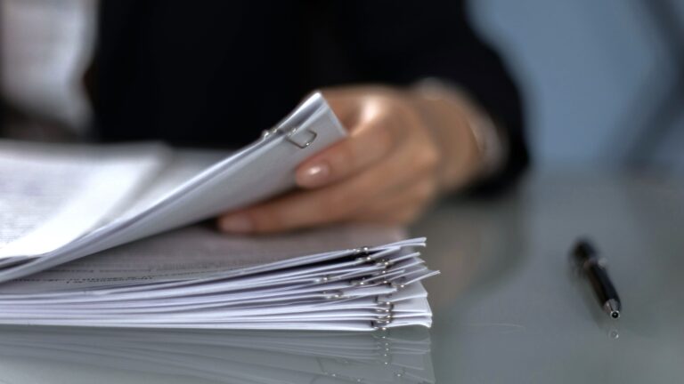 A hand flipping through a document folders