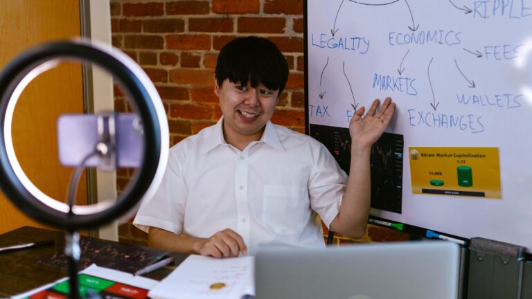 Finfluencer sitting at a desk in front of a camera, pointing at a whiteboard displaying his scheme