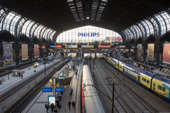 View of a busy European train station with multiple platforms and trains