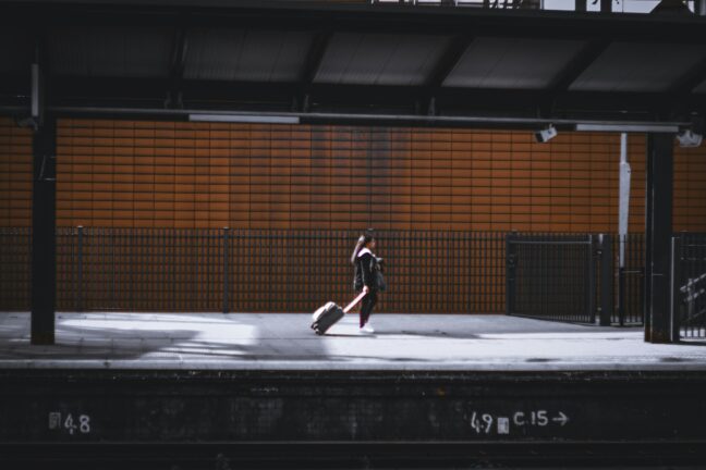 Woman with a suitcase walking on a train station platform