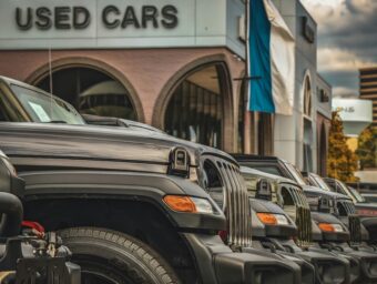 Used car dealership with a row of vehicles parked outside.