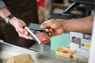 A customer paying by card at a shop terminal