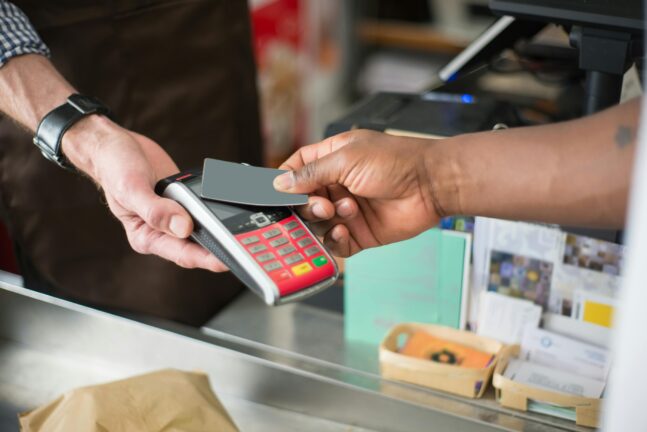 A customer paying by card at a shop terminal