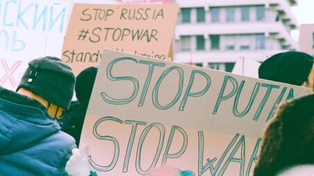 Protesters holding banners at a demonstration against Russia’s war in Ukraine