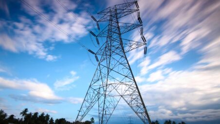 High-voltage electricity transmission tower against the sky