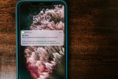A phone screen showing a fraudulent bank notification warning about unusual account activity