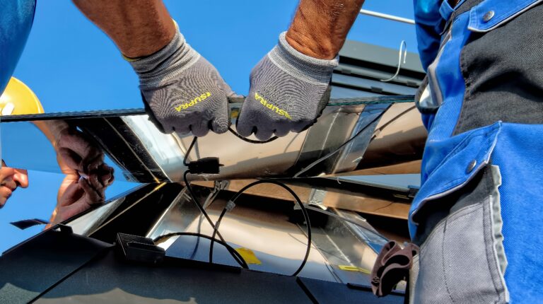 A technician installing a solar panel, with cables visible underneath.