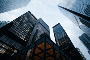 Glass-clad bank skyscrapers photographed from below against a cloudy sky
