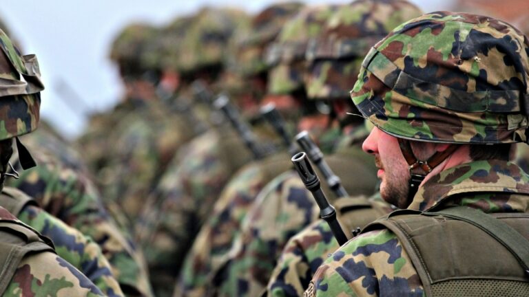 Rows of soldiers in helmets and camouflage uniforms