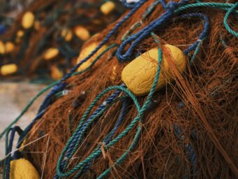 Fishing nets piled up at a harbour