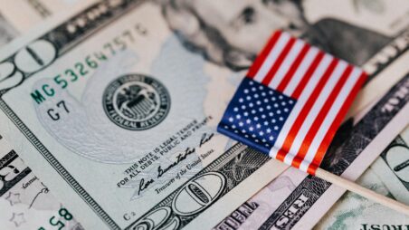 A 20-dollar banknote with a small American flag placed on top of it