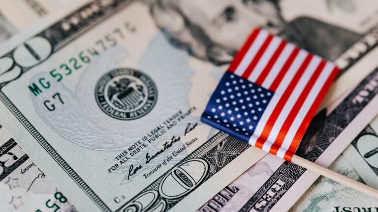 A 20-dollar banknote with a small American flag placed on top of it
