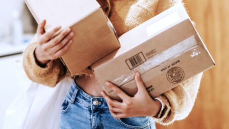 Close-up of a woman holding two cardboard parcels
