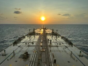 View along the deck of an oil tanker toward the horizon at sunset