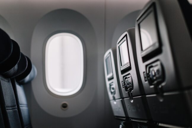 11:28Claude responded: Airplane seats and headrests viewed from the aisleAirplane seats and headrests viewed from the aisle