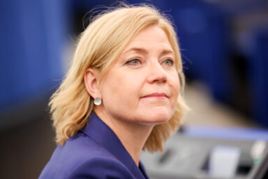 Henna Virkkunen, wearing a purple blazer, looking to the side during a European Parliament plenary session