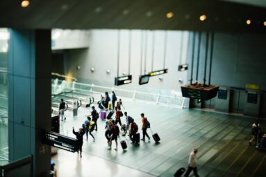 Travellers with luggage walking through an airport terminal