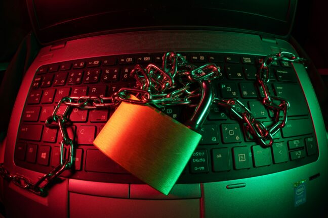 Computer keyboard covered by a chain and padlock