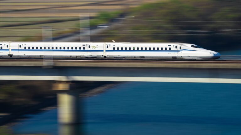 A high-speed train crossing a bridge over water