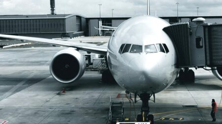 Commercial aircraft at an airport gate with a boarding bridge