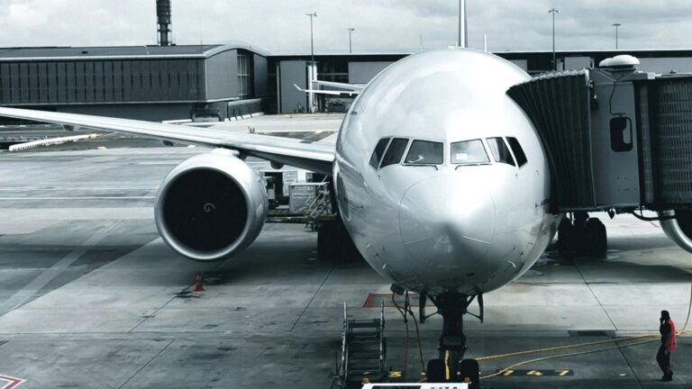 Commercial aircraft at an airport gate with a boarding bridge