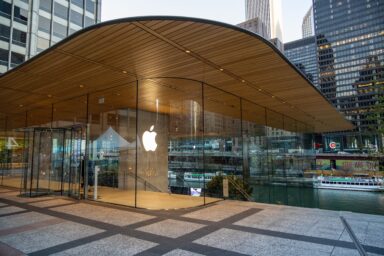 Apple store with curved wooden roof and illuminated logo on glass facade in Chicago
