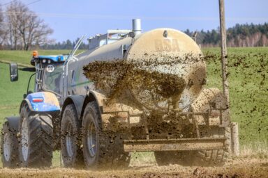 A tractor spreading manure on a field
