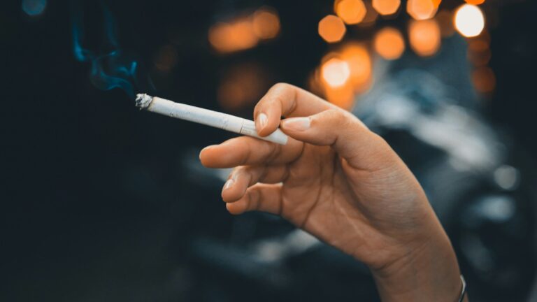 Hand holding a lit cigarette