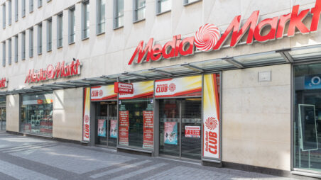 Exterior of a MediaMarkt store on a pedestrian street, with red signage above the entrance.