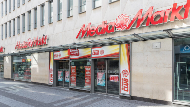 Exterior of a MediaMarkt store on a pedestrian street, with red signage above the entrance.