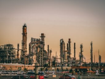 Silhouetted towers and pipework of an oil refinery at dusk